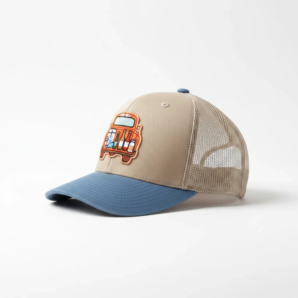 BOX SEAT blue and beige trucker hat featuring an embroidered tailgate truck graphic with drinks on a white background