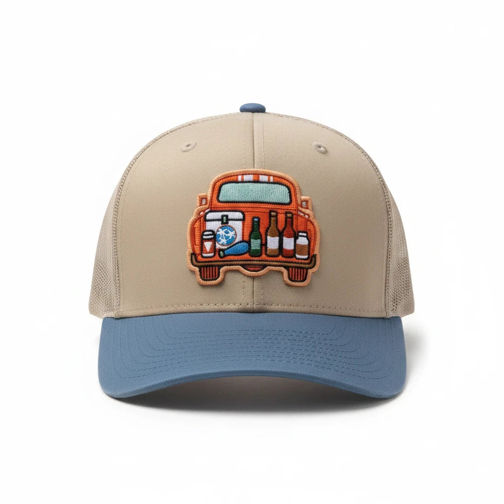 BOX SEAT blue and beige trucker hat featuring an embroidered tailgate scene with a cooler and bottles