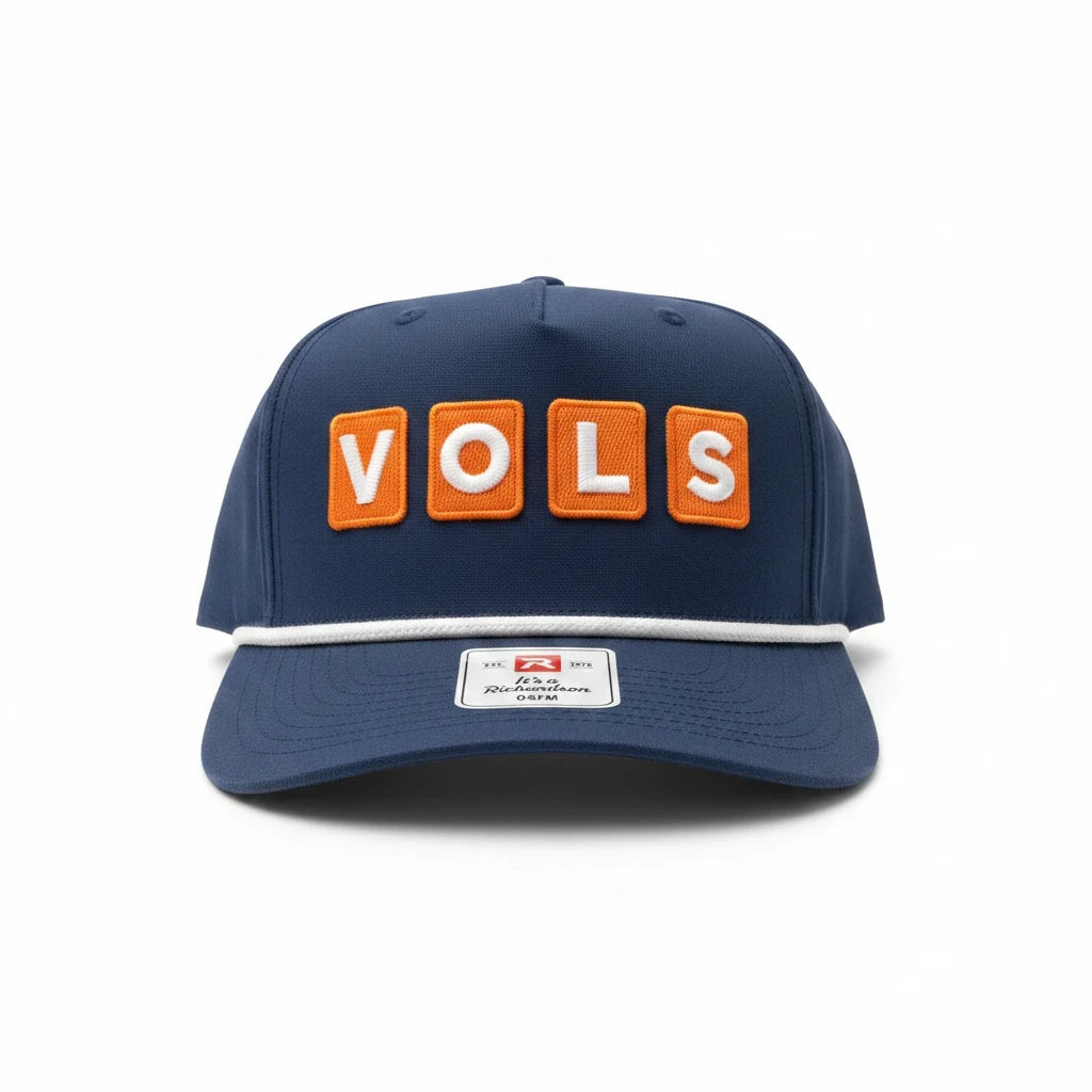 BOX SEAT navy blue snapback hat featuring orange VOLS block letter patches and a white rope detail on the brim